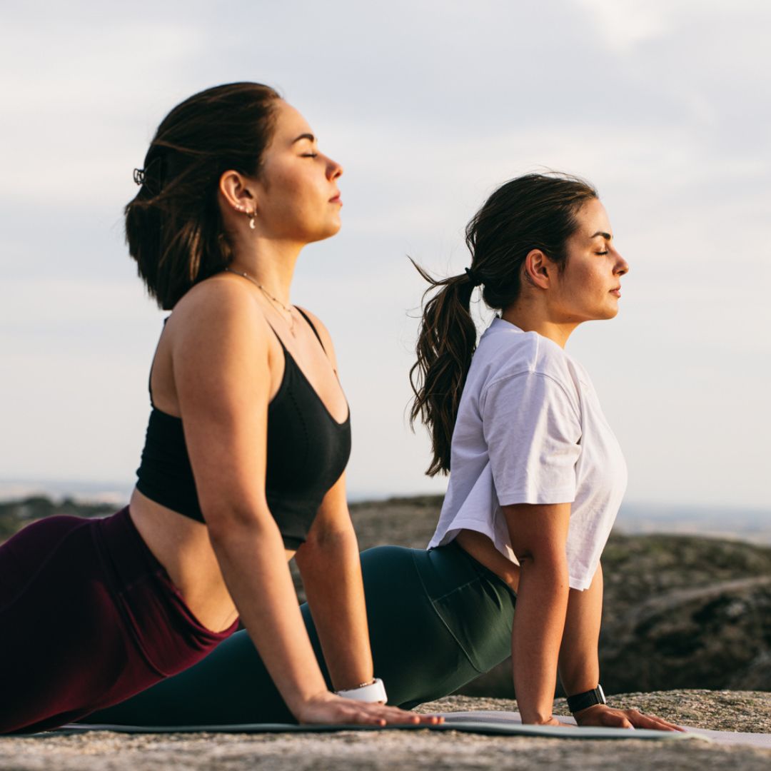 mujeres haciendo yoga para aliviar el estres